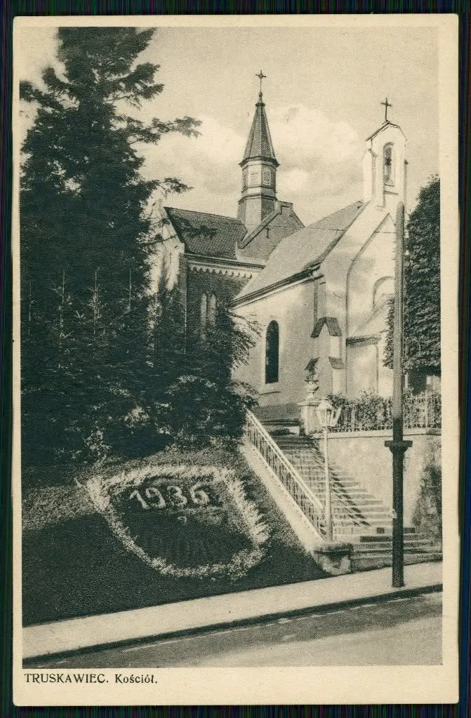 Римо-католицький костел у Трускавці на листівці 1930-х: мурований храм з гострою вежею, а на схилі з квітів викладено рік 1936