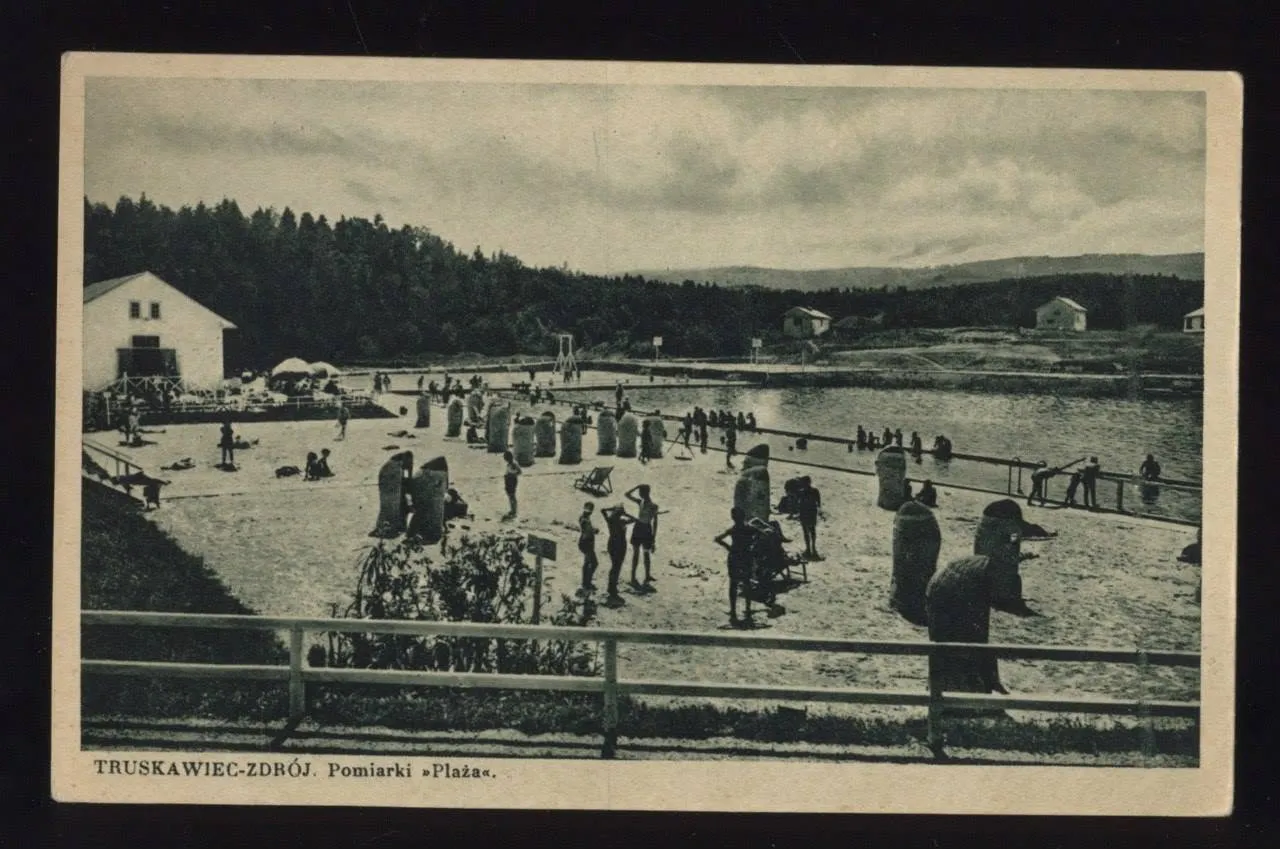Піщаний пляж «Помярки» у Трускавці 1930-х: плетені коші-кабінки, купальники на піску, басейн і білий павільйон серед лісистих пагорбів